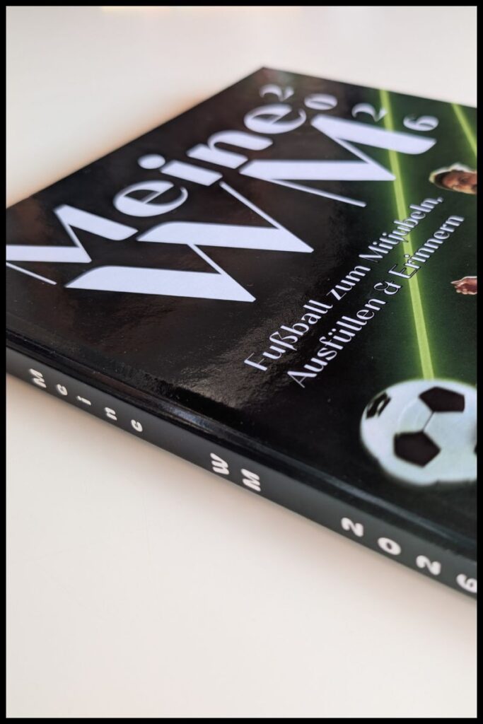 Das Fußball WM Mitmachbuch für Kinder - "Meine WM 2026" Seitliche Ansicht auf das Mitmachbuch zur WM "Meine WM 2026" zur Fußball-WM mit Blick auf den Buchrücken
