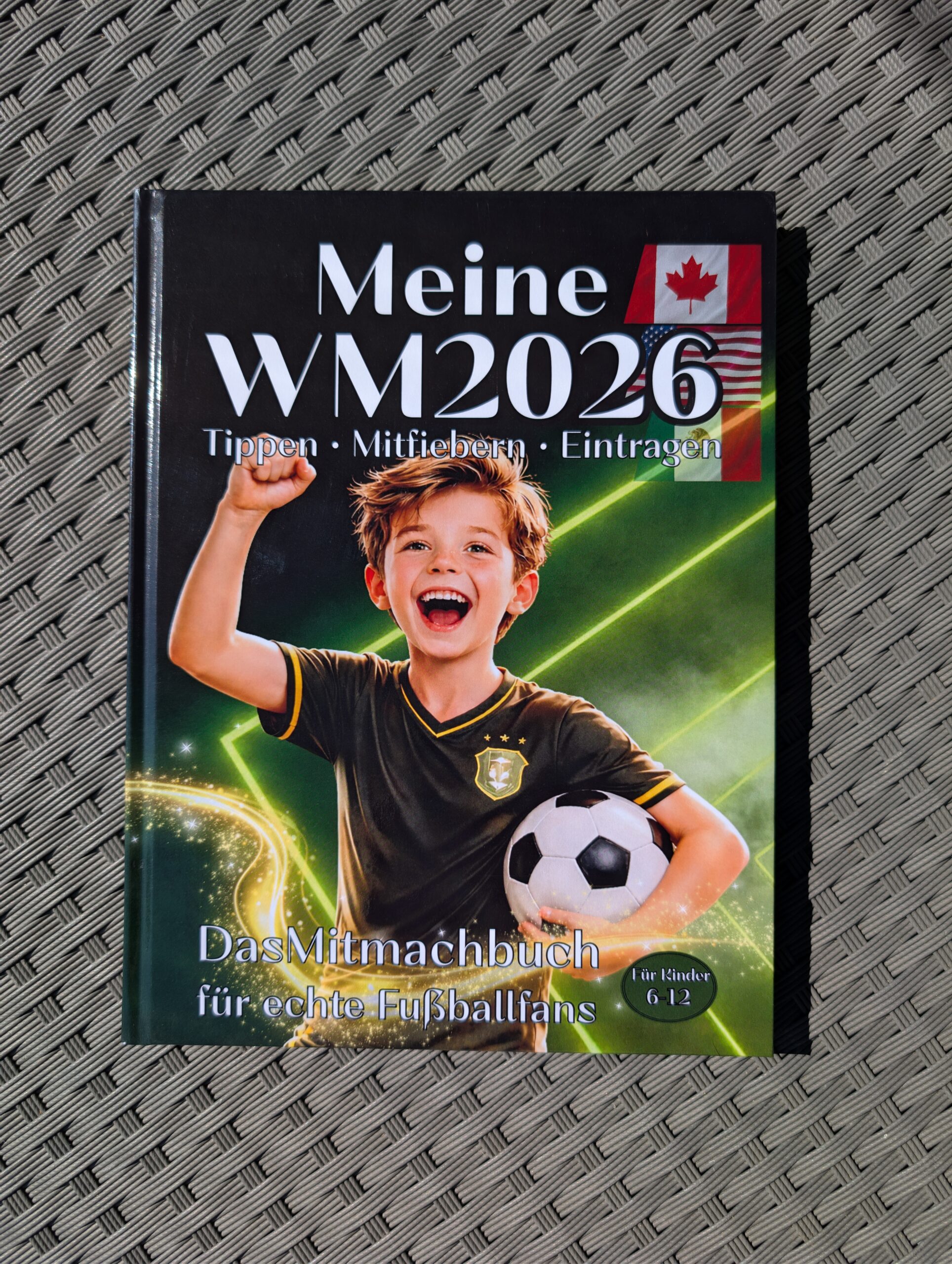 Mitmachbuch "Meine WM 2026" ein jubelnder Junge im Trikot und einem Ball unterm Arm.