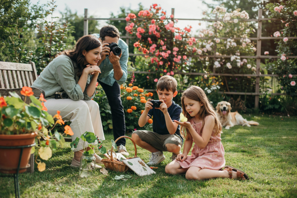 Kinder fotografieren Blumen, Insekten und Naturdetails bei einer kreativen Foto-Challenge im Garten und schaffen gemeinsame Familienerinnerungen.