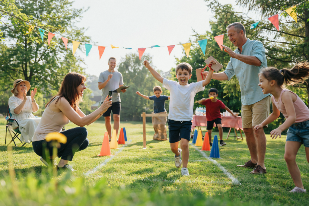 Kinder nehmen gemeinsam mit Eltern und Großeltern an einer lustigen Mini-Olympiade im Garten teil und erleben aktive Familienzeit.