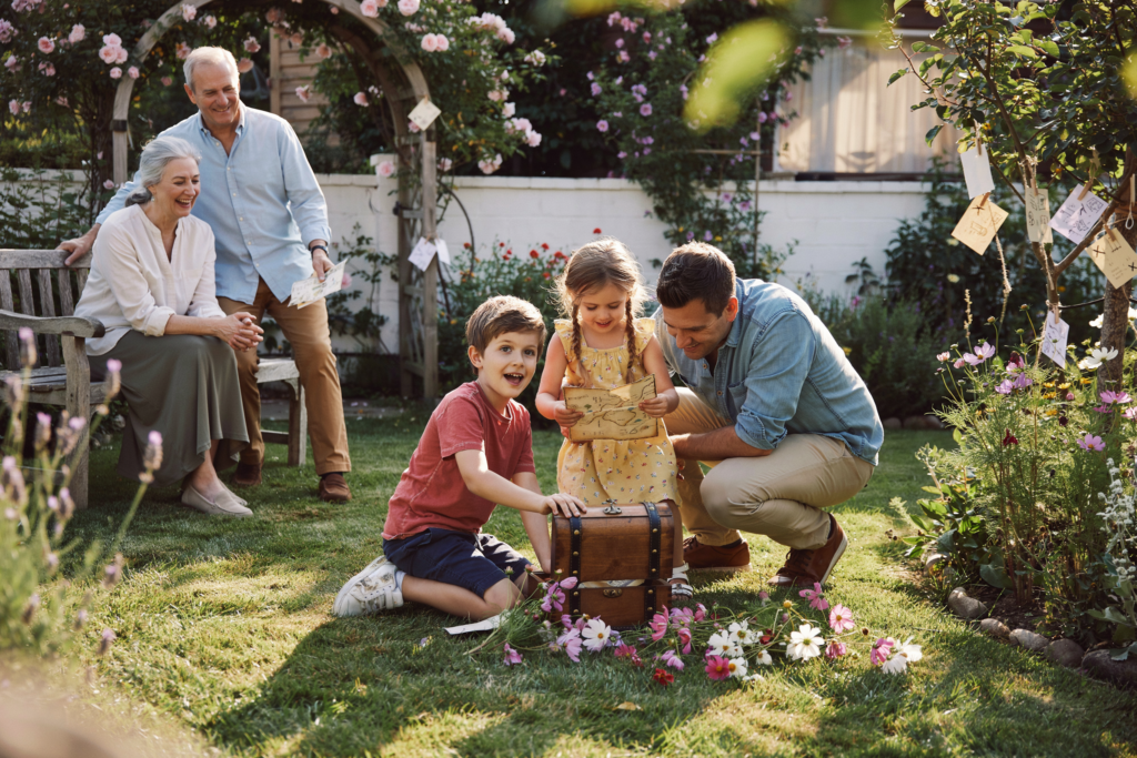 Kinder entdecken bei einer spannenden Schatzsuche im Garten gemeinsam Hinweise und erleben ein aufregendes Familienabenteuer.
